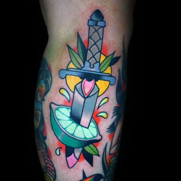 Bold traditional tattoo featuring a dagger piercing a lime wedge, with vibrant colors and juice splashes for a dynamic and striking design.