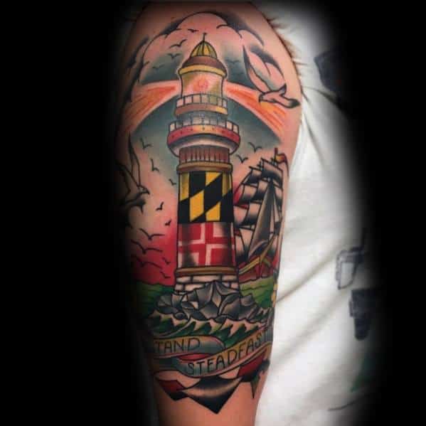 Maryland-themed lighthouse tattoo on the upper arm, featuring the state flag pattern, a sailing ship, and a "Stand Steadfast" banner for a nautical look.