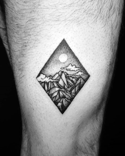 Diamond-shaped mountain tattoo with detailed dot work, featuring rugged peaks, clouds, and a full moon for a bold yet artistic landscape design.