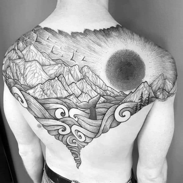 Intricate black ink back tattoo featuring swirling waves, towering mountains, a whale tail, and a dark sun, creating a bold and dramatic nature scene.