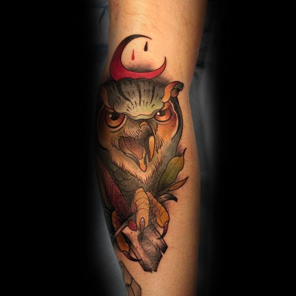 Neo-traditional owl tattoo with fierce eyes, bold shading, and a crescent moon accent, creating a striking and mystical forearm design.