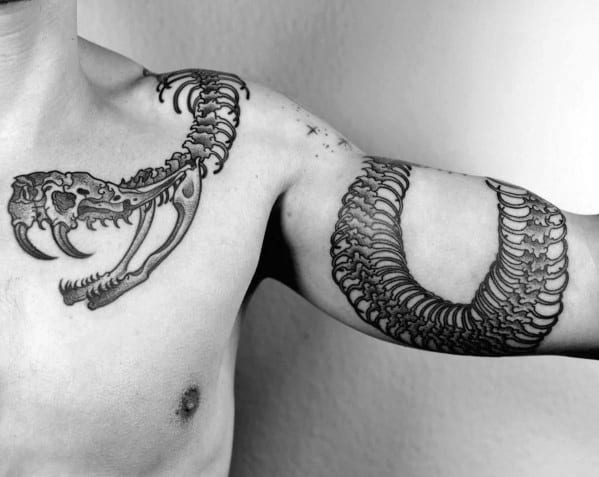 Snake skeleton tattoo extending across the chest and arm, featuring a detailed skull and ribcage for a bold and dynamic design.