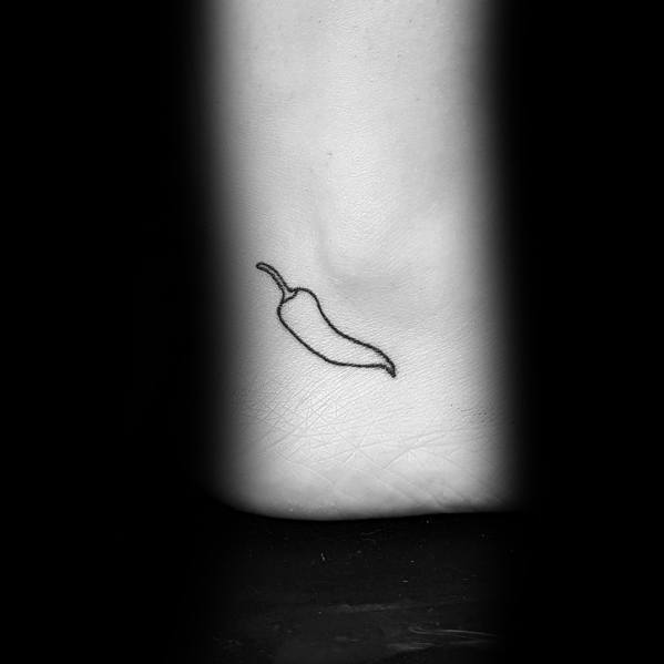 Minimalist chili pepper tattoo on the ankle with a simple black outline for a subtle and sleek design.