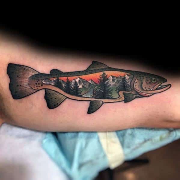 Unique salmon tattoo with a scenic landscape inside its body, featuring mountains, trees, and a sunset, blending nature and wildlife symbolism.