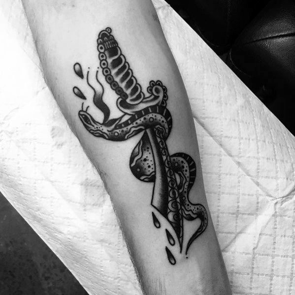 Black and grey snake and dagger tattoo on forearm, featuring bold lines, intricate shading, and blood drops for a classic traditional design.