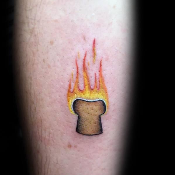 Minimalist burning toast tattoo with bold flames rising from a simple bread slice, blending humor and symbolism in a small, vibrant design.