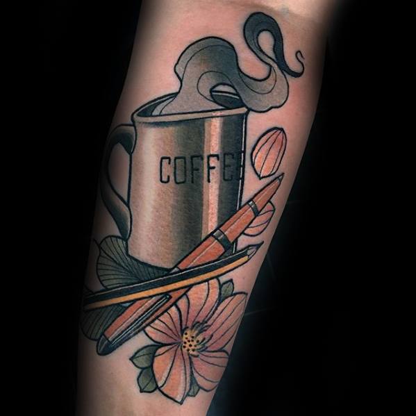 Tattoo of a steaming coffee mug with flowers and an open pen, complemented by a pencil