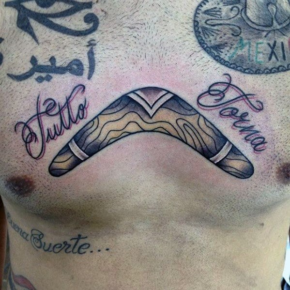 Boomerang chest tattoo with woodgrain texture, framed by the cursive Italian phrase Tutto Torna meaning everything returns.