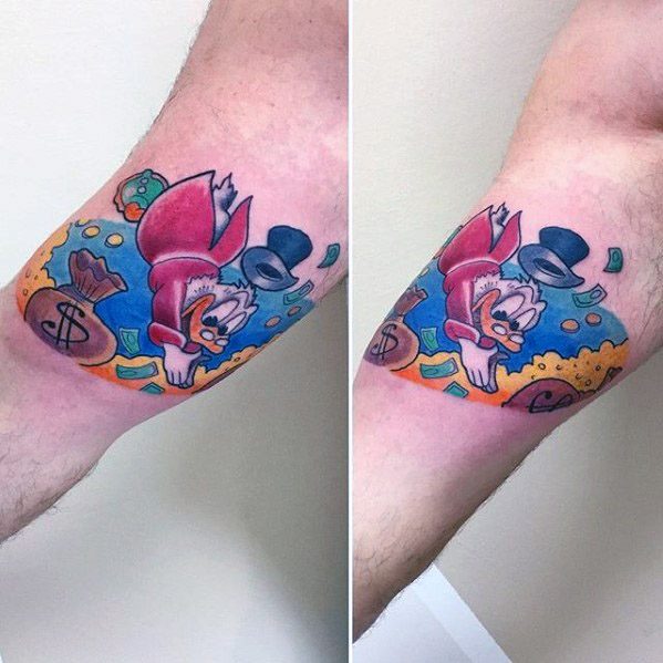 Vibrant tattoo of Scrooge McDuck diving into gold coins with a flying top hat, placed on the arm with rich colors and dynamic motion.