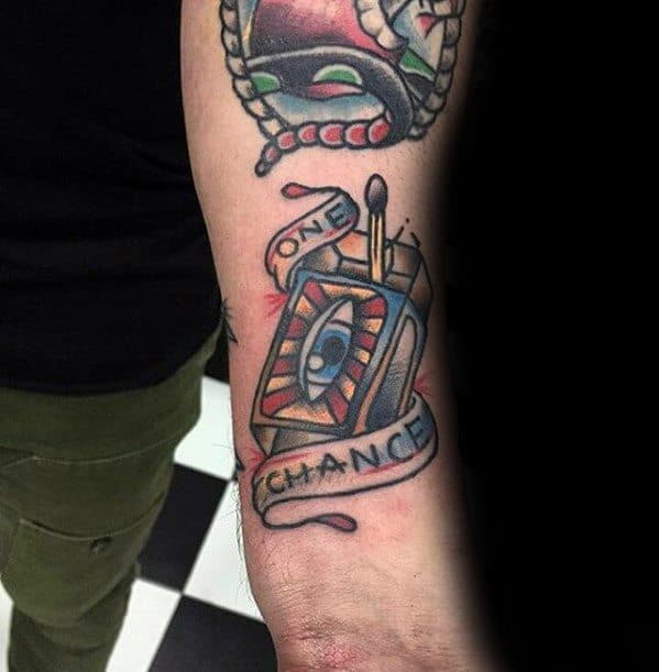 Traditional matchbox tattoo with an eye and “One Chance” banner, symbolizing risk, awareness, and the power of a single moment.