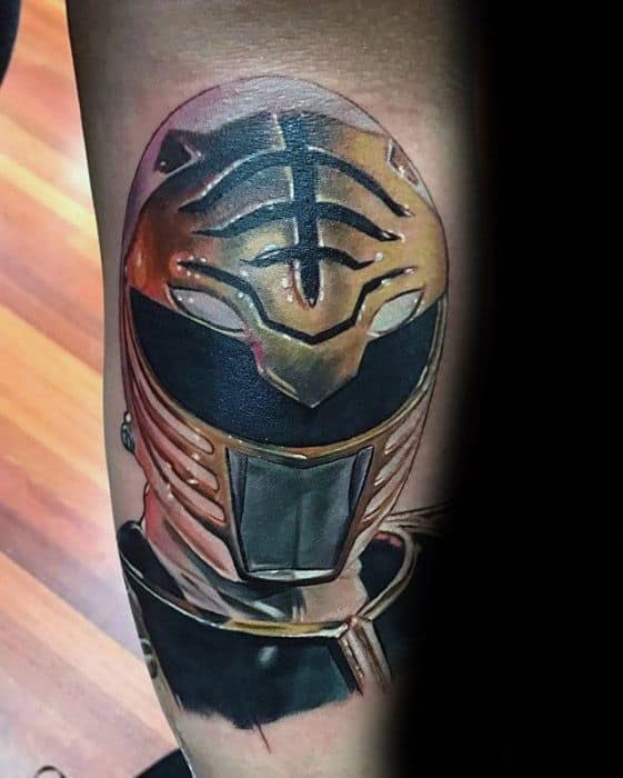 Realistic tattoo of the White Ranger helmet with detailed reflections, rich gold tones, and high-contrast shading on the arm.
