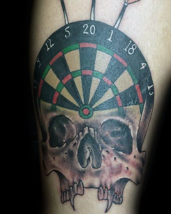 Bold tattoo of a dartboard merged with a skull, featuring three darts on top and dark shading for a dramatic, edgy look.