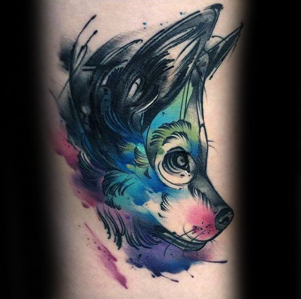 Playful watercolor wolf tattoo with large expressive eyes, sketch-style outlines, and vibrant splashes of blue, purple, and pink.