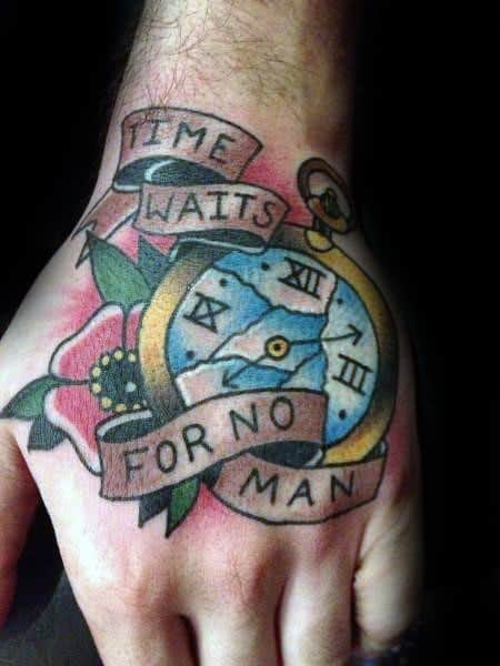 Colorful hand tattoo featuring a broken pocket watch, flower, and ribbon with the phrase Time Waits for No Man.