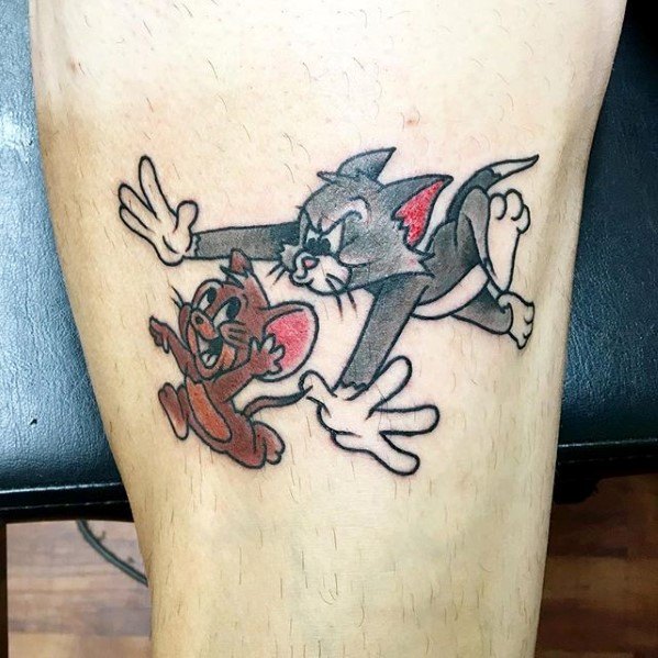 Colorful leg tattoo of Tom chasing Jerry in mid-air, capturing their classic cartoon antics and playful expressions.