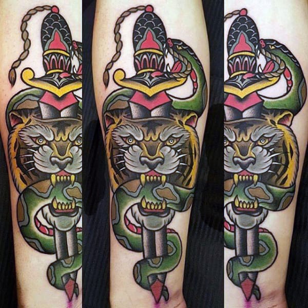 A tattoo of a tiger, snake, dagger, and a decorative helmet on a forearm