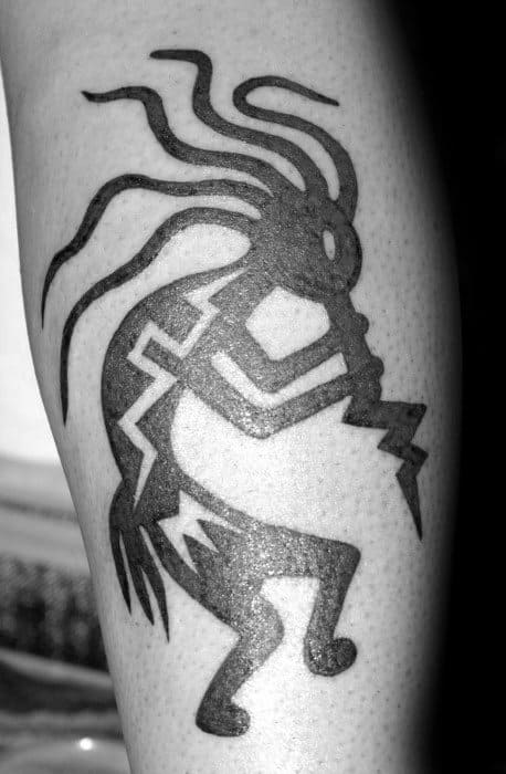 Bold Kokopelli tattoo with thick black lines and zigzag patterns, featuring flowing hair and a dynamic flute-playing pose.