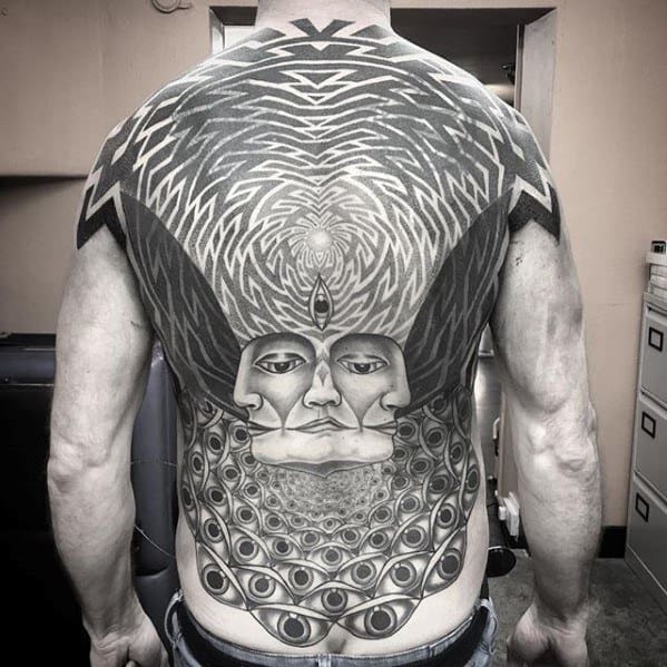 Surreal full-back tattoo featuring mirrored faces with a third eye, radiating patterns above, and cascading rows of eyes below.