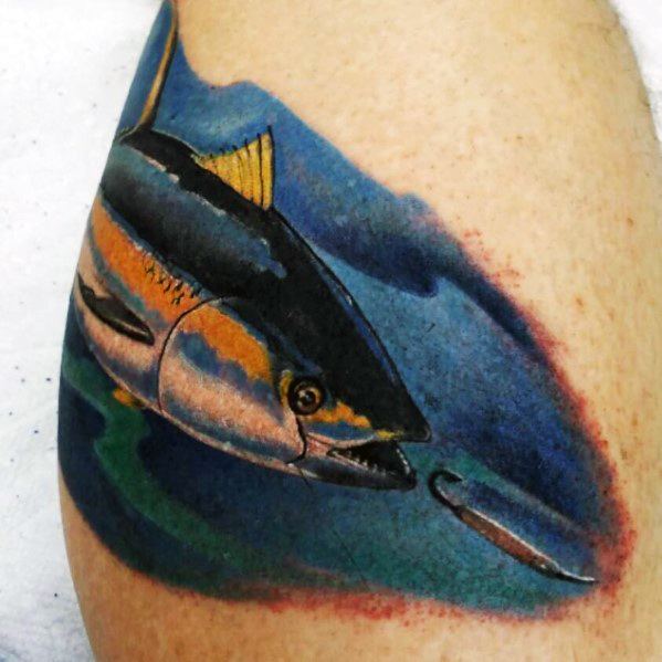 Realistic tuna fish tattoo on a man's arm, featuring vibrant colors, underwater shading, and a detailed fishing hook for a dynamic design.