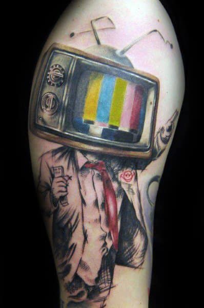Tattoo of a suit-wearing figure with a vintage TV for a head, displaying color bars, holding a remote, and pointing forward in a surreal style.