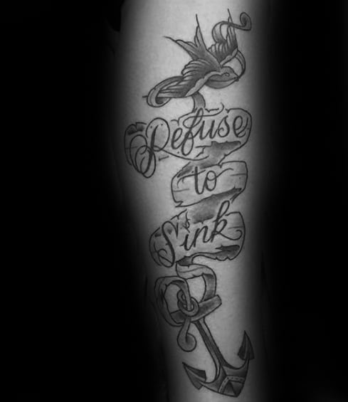 Tattoo of a swallow, anchor, and "Refuse To Sink" text on a person's arm