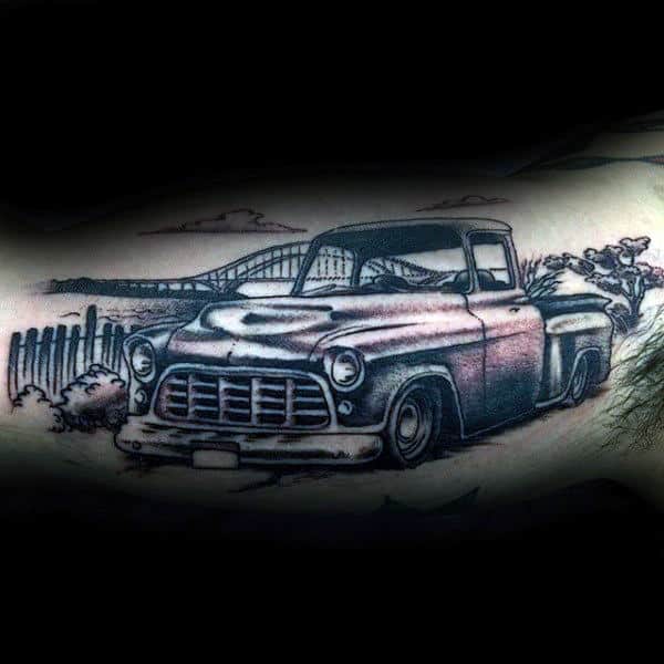 Guys Vintage Black And Grey Truck Tattoo With Landscape Of Bridge In Background On Arm