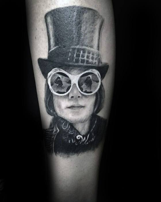 Black and grey Willy Wonka tattoo featuring large round sunglasses, a tall top hat, and a mysterious expression.