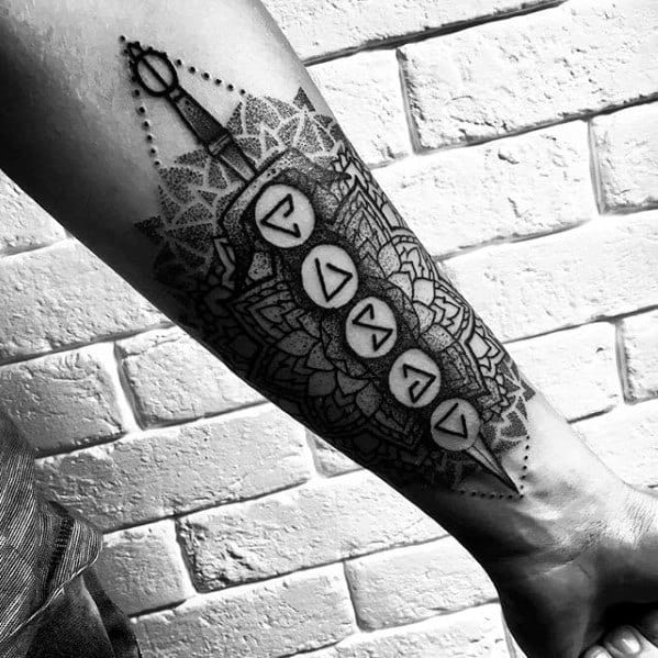 Geometric Witcher tattoo on the forearm featuring magical signs, mandala patterns, and a sword at the top in fine dotwork style.