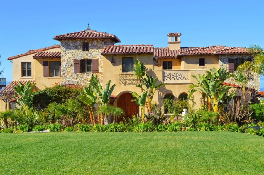 large hacienda style spanish home with green lawn