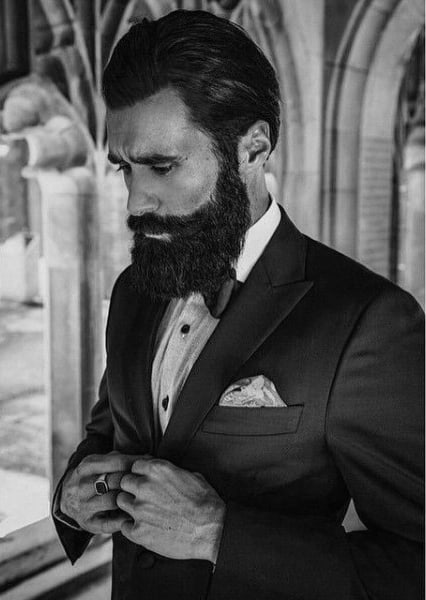 Man with slicked-back hair and a full beard