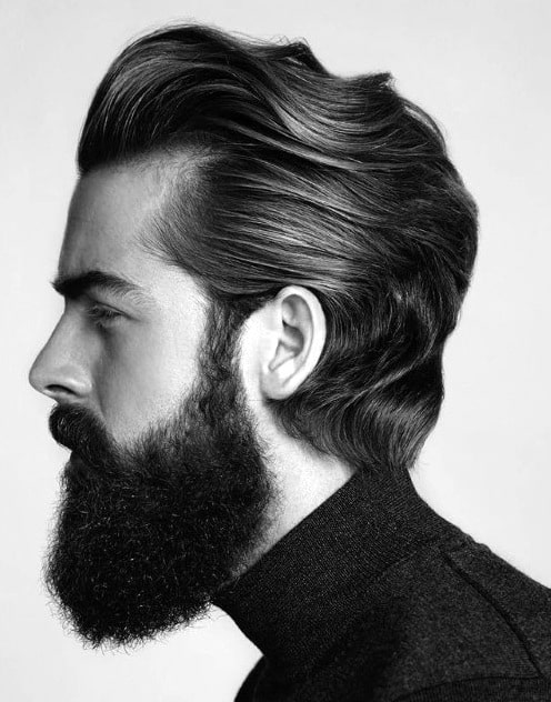 Man with slicked-back medium-length hair and a full beard