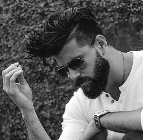 Man with a tousled undercut hairstyle and a full beard