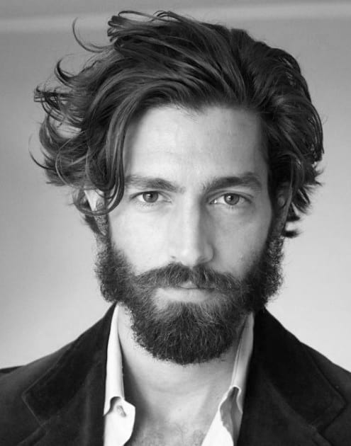 Man with wavy, medium-length hair and a full beard