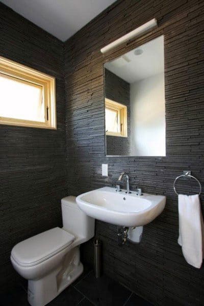 black textured tile bathroom with white sink and toilet