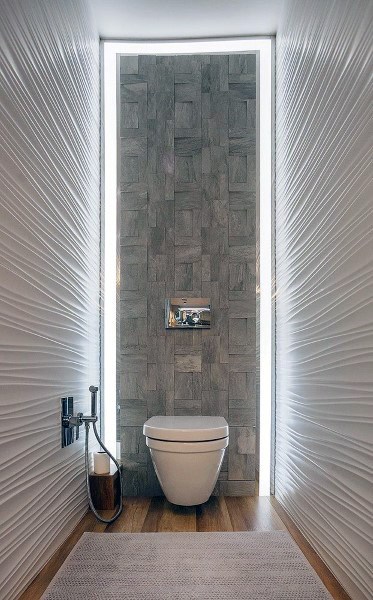 Modern half bath with a wall-mounted toilet, textured walls, wood flooring, and ambient lighting