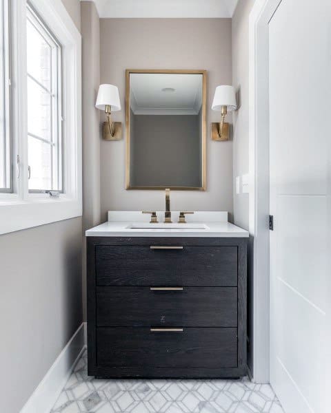 narrow bathroom with black cabinet vanity and gold accents