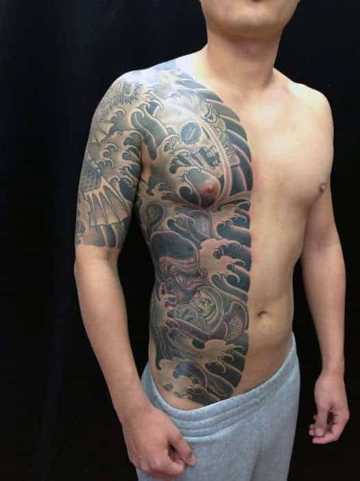 Japanese half-chest and side tattoo featuring a detailed octopus, ocean waves, and intricate shading in black and grey