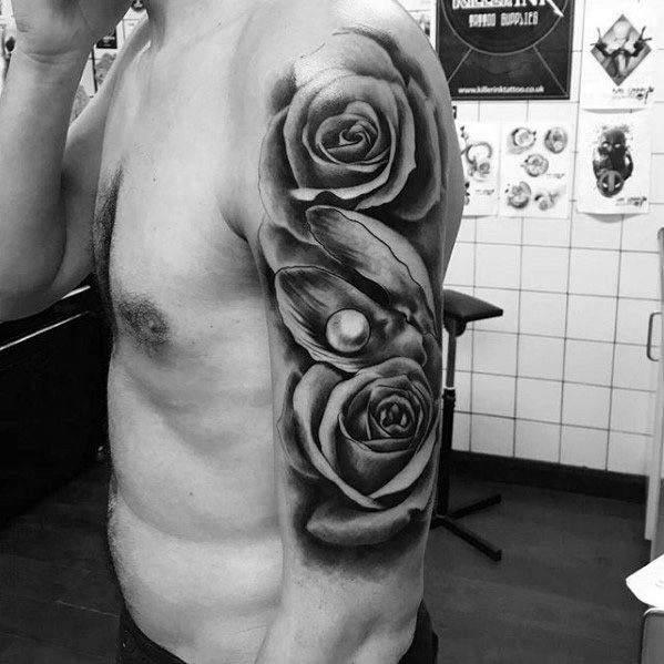 Black and grey arm tattoo featuring realistic roses and an open clam shell with a pearl nestled between the flowers.