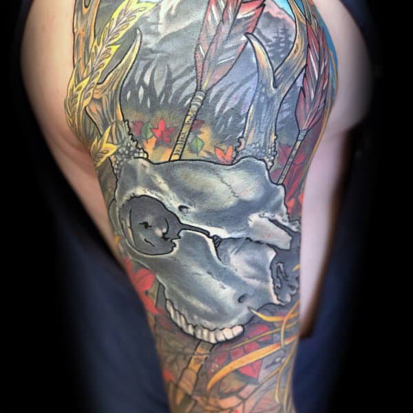 Vibrant full arm tattoo featuring a deer skull, colorful arrows, and autumn leaves, blending hunting imagery with bold artistic flair.