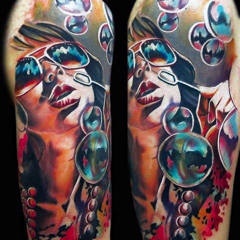 Tattoo of a woman wearing sunglasses surrounded by colorful bubbles, blending bold colors and soft gradients to create a dynamic and playful composition.