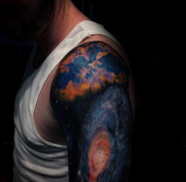Person in a sleeveless shirt, showing off a colorful nebula-themed tattoo covering their shoulder and upper arm