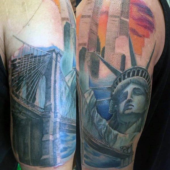 Colorful upper arm tattoo featuring the Statue of Liberty, Brooklyn Bridge, and NYC skyline with a vibrant sunset background.
