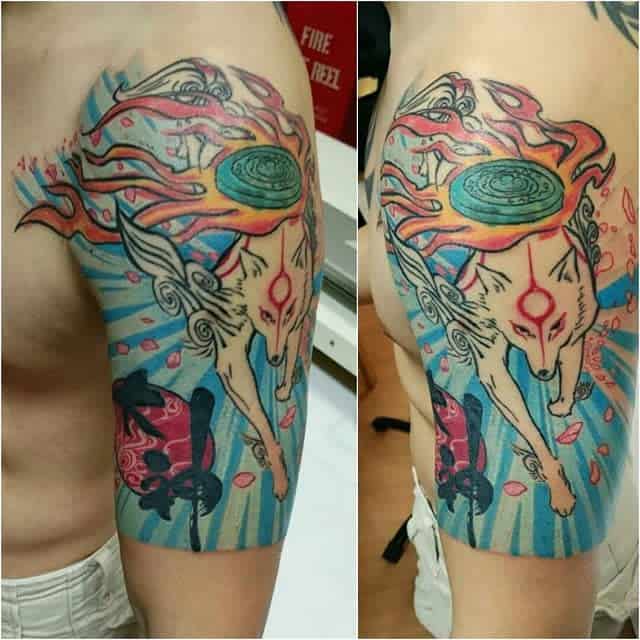 Bold half-sleeve Okami tattoo of Amaterasu with flowing flames, a radiant sun disc, and vibrant blue waves, capturing divine energy in motion
