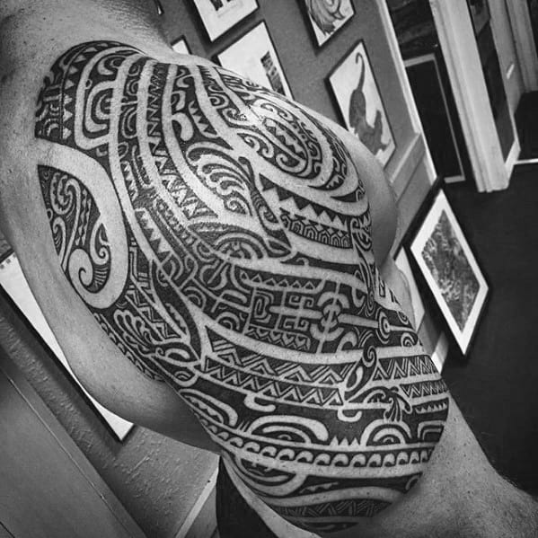 Large tribal gecko tattoo covering shoulder and upper arm, featuring intricate Polynesian patterns and bold black ink.