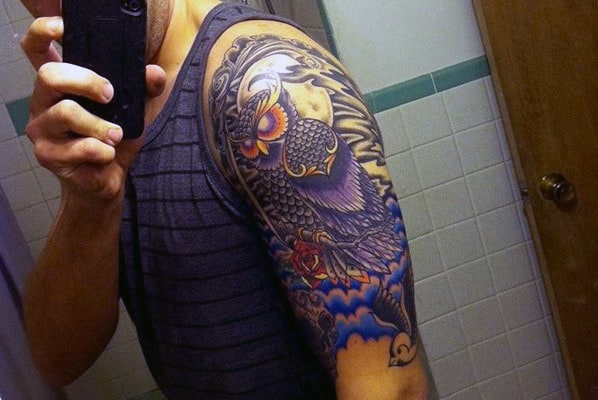 Detailed owl tattoo on an upper arm