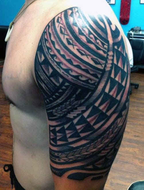 Person with an intricate tribal tattoo on their upper arm and shoulder