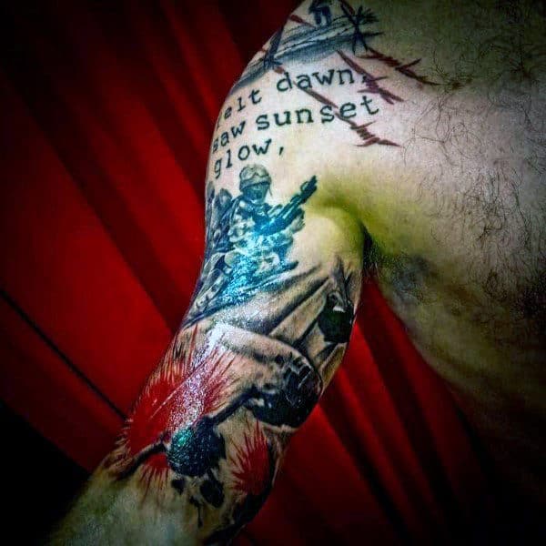 An arm tattoo of soldiers, text, and a barbed wire design