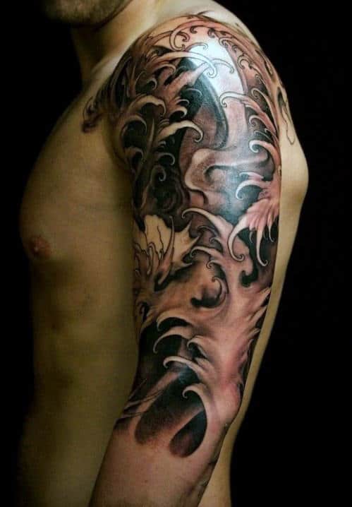 Man's upper arm with detailed, dark, and intricate wave-themed tattoo sleeve