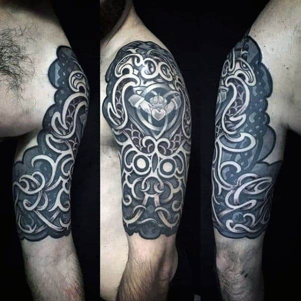Black and grey intricate ornamental sleeve tattoo on an upper arm