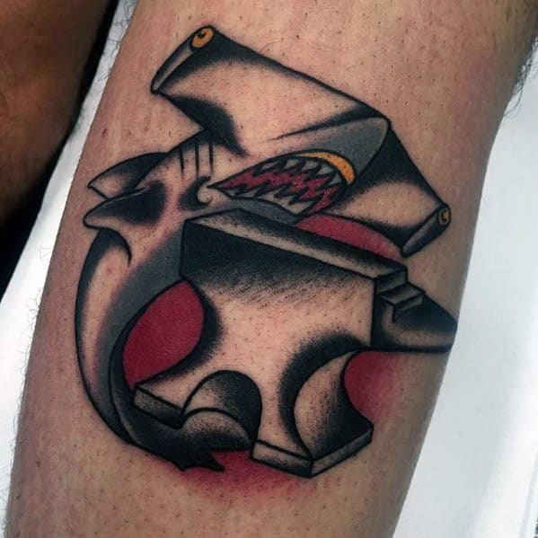 Bold anvil tattoo with a snarling snake hidden inside the top, accented by red shading and sharp black outlines for a fierce, dynamic effect.